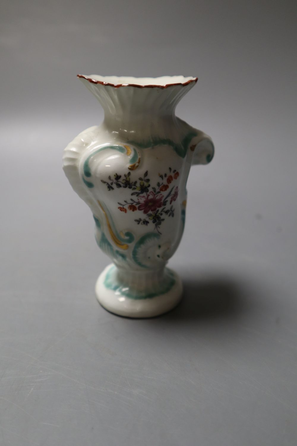A Derby asymmetric vase moulded with rococo scrolls and painted with flower and a Derby plate painted with flower,